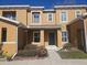 Tan two-story townhome with a dark green door and landscaping at 2566 Sea Wind Way, Clearwater, FL 33763