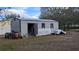 Gray metal storage shed with side door and window at 26341 Dayflower Blvd, Wesley Chapel, FL 33544