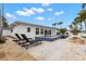 Backyard with a pool, sun loungers, an outdoor fireplace and manicured palm trees at 280 N Julia Cir, St Pete Beach, FL 33706