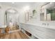 Bright bathroom with double vanity, basket storage, and arched mirror reflecting the bedroom at 280 N Julia Cir, St Pete Beach, FL 33706