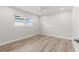 Minimalist bedroom with light-colored walls, wood floors, and a window with neighborhood views at 280 N Julia Cir, St Pete Beach, FL 33706