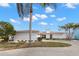 Exterior shot of a modern home showcasing a well-maintained lawn and circular driveway at 280 N Julia Cir, St Pete Beach, FL 33706