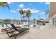 Inviting waterfront pool area with lounge chairs and lush palms, perfect for relaxation by the water at 280 N Julia Cir, St Pete Beach, FL 33706