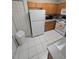 View of kitchen with white appliances and wood cabinets at 30119 Wellesley Way, Wesley Chapel, FL 33543