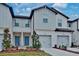 Two-story townhome with gray siding, two-car garage, and landscaped front yard at 31424 Amberview Bend, Wesley Chapel, FL 33545