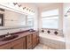 Bathroom boasts double vanity, bathtub, and tiled floors at 3391 Knox Ter, Port Charlotte, FL 33948