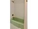 Bathroom with a light green tub and white tile at 36847 Jefferson Ave, Dade City, FL 33523