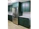 Modern kitchen with stainless steel appliances and dark green cabinetry at 36847 Jefferson Ave, Dade City, FL 33523