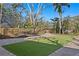 Private backyard featuring artificial turf, paver pathways, and a charming fence for a secluded oasis at 4407 W Dale Ave, Tampa, FL 33609