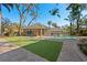 Landscaped backyard featuring a guest house, pool, and patio, complemented by lush green grass at 4407 W Dale Ave, Tampa, FL 33609