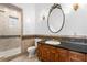 Elegant bathroom features tiled shower, decorative wall trim, and ornate mirror over dark wood vanity at 4407 W Dale Ave, Tampa, FL 33609
