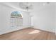 Bright bedroom featuring hardwood floors, a tray ceiling and a large arched window at 4407 W Dale Ave, Tampa, FL 33609