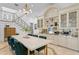 Bright dining area with marble table, chandelier, and staircase with decorative wrought iron at 4407 W Dale Ave, Tampa, FL 33609