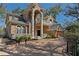 Luxury home featuring a brick facade, arched entry, upper balcony, and manicured landscaping at 4407 W Dale Ave, Tampa, FL 33609