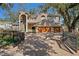 Stately brick home with a two-car garage, balcony, mature trees and an ornate front gate at 4407 W Dale Ave, Tampa, FL 33609