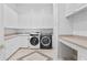 Spacious laundry room with white cabinets, countertops, sink, and modern washer and dryer units at 4407 W Dale Ave, Tampa, FL 33609