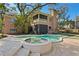 A beautiful home exterior featuring a swimming pool and hot tub, complemented by a spacious backyard and lush landscaping at 4407 W Dale Ave, Tampa, FL 33609
