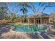 Beautiful pool featuring serene landscaping, a spa, and an inviting pool house for outdoor relaxation and entertainment at 4407 W Dale Ave, Tampa, FL 33609