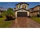 Two-story home with a brown door and brick driveway at 4556 San Martino Dr, Wesley Chapel, FL 33543