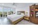 Bright bedroom with a king-size bed, balcony access, and an antique wardrobe at 4823 Ebbtide Ln # 403, Port Richey, FL 34668