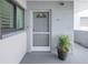 Condo entry with gray door, screen, and potted plant at 4823 Ebbtide Ln # 403, Port Richey, FL 34668