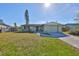 Updated light green house with a paved driveway and landscaped lawn at 6025 Florida S Cir, Apollo Beach, FL 33572