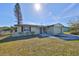 Updated light green house with a paved driveway and landscaped lawn at 6025 Florida S Cir, Apollo Beach, FL 33572