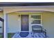 Dark brown front door with a black metal bench on a paved porch at 6025 Florida S Cir, Apollo Beach, FL 33572