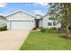 Single-story home with two car garage and landscaped lawn at 711 Old Windsor Way, Spring Hill, FL 34609