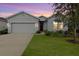 Curb appeal abounds in this charming one-story home, featuring a two-car garage and manicured lawn at 711 Old Windsor Way, Spring Hill, FL 34609