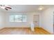 Living room featuring wood-look floors, large window, and entryway at 7499 7Th N St, St Petersburg, FL 33702