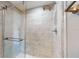 Modern shower with glass enclosure and marble-look tile at 7499 7Th N St, St Petersburg, FL 33702