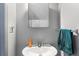 Small bathroom with pedestal sink, mirror, and teal towel at 7606 Woodbridge Blvd, Tampa, FL 33615