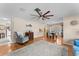 Bright living room with hardwood floors, ceiling fan, and a view into the dining area at 7745 Deer Foot Dr, New Port Richey, FL 34653