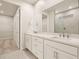 Double vanity bathroom with a large mirror and a walk-in shower at 11498 Boundless Ter, Venice, FL 34293