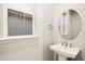 Modern bathroom features a pedestal sink, oval mirror, and updated fixtures at 11498 Boundless Ter, Venice, FL 34293