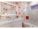 Bright bathroom featuring a glass shower door, white vanity with lighted mirror, and tropical wallpaper at 1902 4Th E St, Palmetto, FL 34221