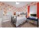 Bedroom featuring tropical wallpaper, white wainscoting, and a wrought iron bed frame, with a connecting bathroom at 1902 4Th E St, Palmetto, FL 34221