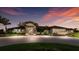 An eye-level exterior shows a landscaped entrance and circle drive at dusk at 1902 4Th E St, Palmetto, FL 34221