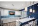 Modern kitchen with white cabinets, sleek countertops, breakfast bar and a stylish blue backsplash at 1902 4Th E St, Palmetto, FL 34221