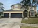 Two-story house with three-car garage and landscaped lawn at 19029 Chislehurst Dr, Land O Lakes, FL 34638