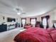 Main bedroom featuring a comfortable sitting area and red bedding at 19029 Chislehurst Dr, Land O Lakes, FL 34638