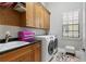 Bright laundry room with wood cabinets, a utility sink, and washer/dryer at 1903 Haven Bend, Tampa, FL 33613