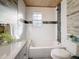 Clean bathroom with white tile, wood-look floor and a built-in shower at 2446 Belleair Rd, Clearwater, FL 33764