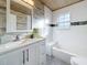Updated bathroom with white subway tiles, wood-look floors, and a walk-in shower at 2446 Belleair Rd, Clearwater, FL 33764