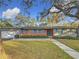 Brick ranch house with teal shutters, attached garage, and landscaped lawn at 2446 Belleair Rd, Clearwater, FL 33764