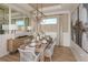 Elegant dining room with wood table, gray chairs, and statement art at 29555 Zupetta Ln, Wesley Chapel, FL 33545