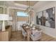 Bright dining room with a wood table, wicker chairs, and modern lighting at 29555 Zupetta Ln, Wesley Chapel, FL 33545