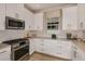Modern kitchen with white cabinets, granite countertops, and stainless steel appliances at 29555 Zupetta Ln, Wesley Chapel, FL 33545