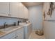 Bright laundry room with washer, dryer, cabinets, and sink at 29555 Zupetta Ln, Wesley Chapel, FL 33545